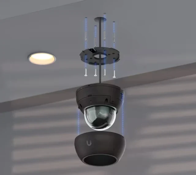 Telecamera dome nera fissata al soffitto, con elementi di montaggio visibili