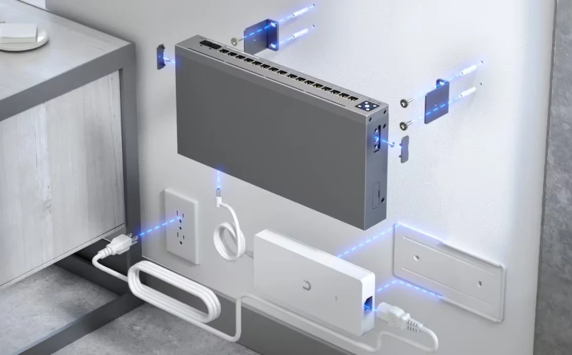 Üst kısmında bağlantı noktaları ve kablolar takılıyken mavi aydınlatma bulunan gri duvar tipi switch