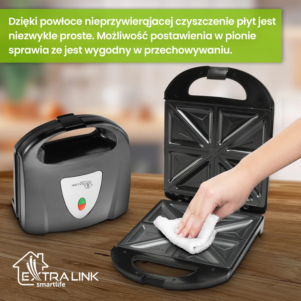 Czarny opiekacz ustawiony pionowo obok otwartego urządzenia czyszczonego ściereczką