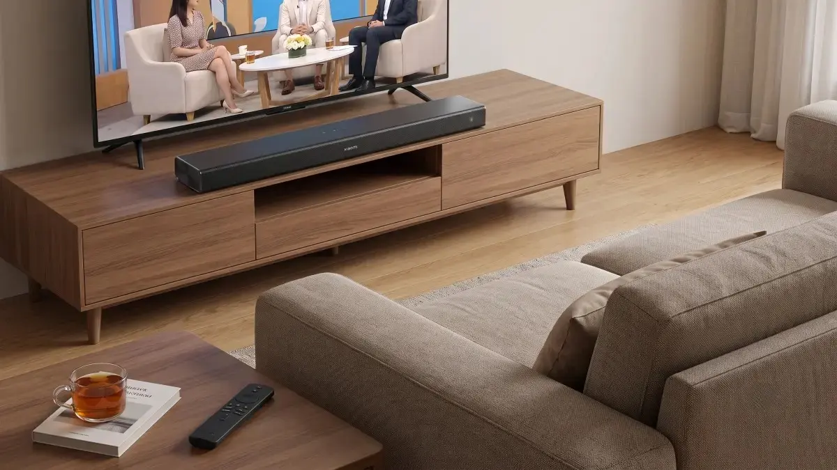 Soundbar asetettuna television eteen puisen kaapin päälle tyylikkäässä olohuoneessa.