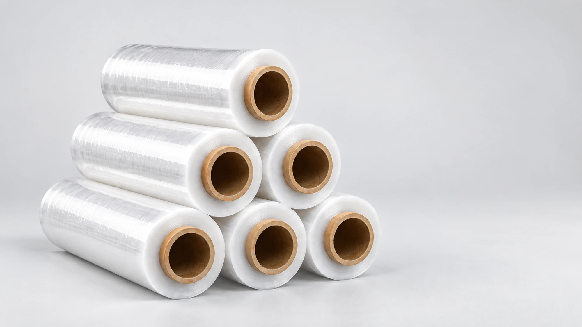 Stack of transparent rolls of Extralink stretch film with cardboard cores