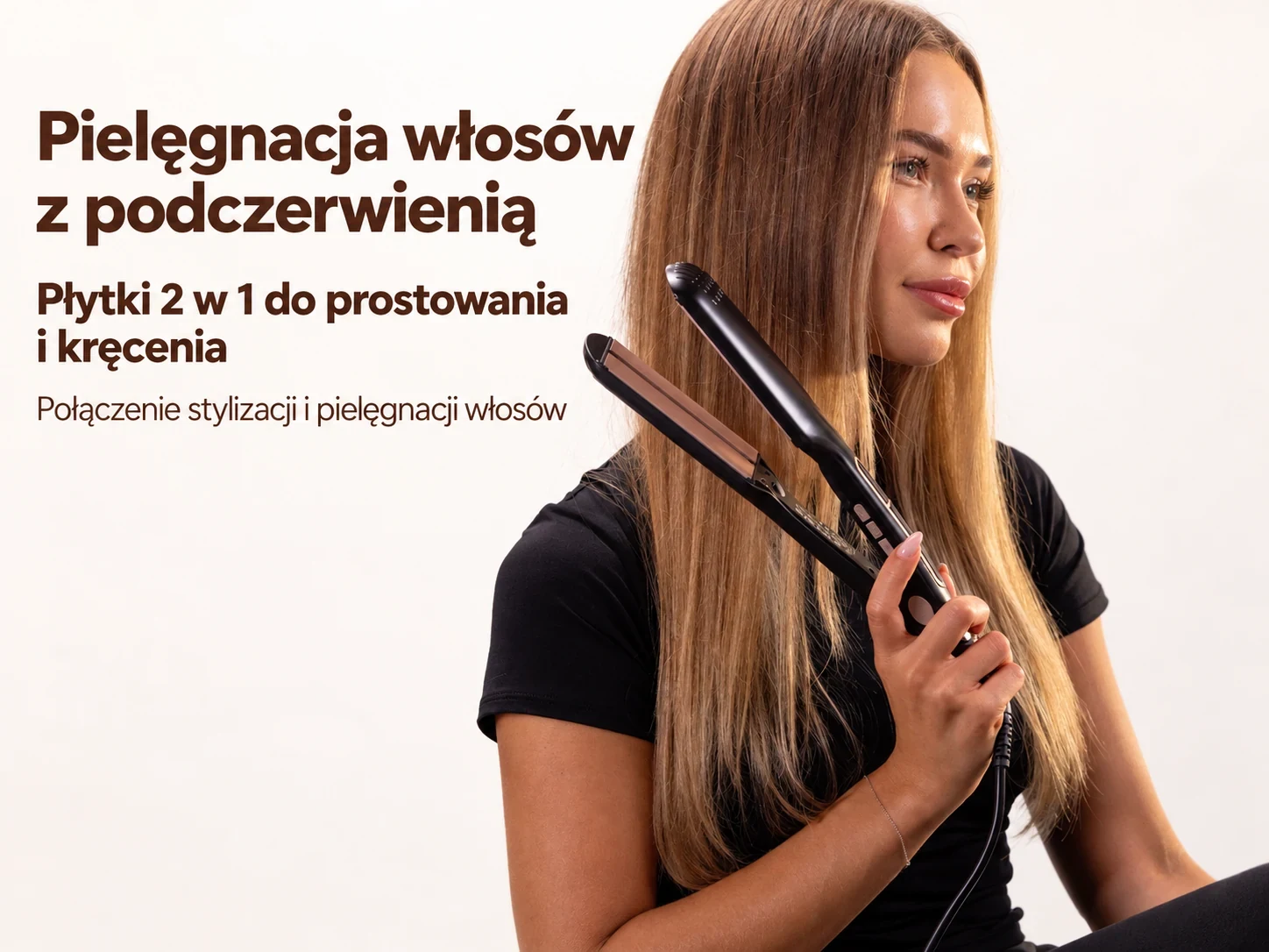 Czarna prostownica Stay Beauty trzymana przy długich włosach przez kobietę