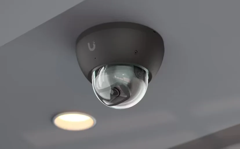 Cámara domo negra instalada en el techo, con cubierta transparente para el objetivo