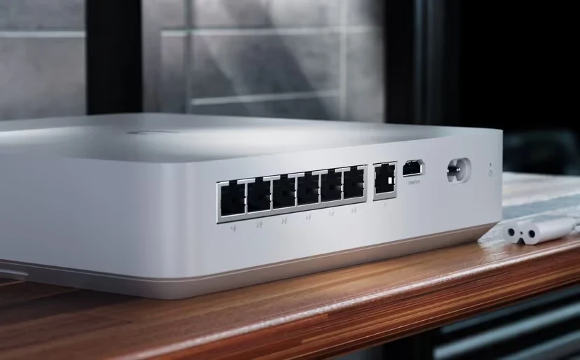Valkoinen tallennin useilla Ethernet-porteilla ja virtapistokkeella puisella pinnalla