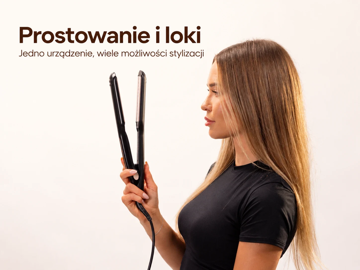 Kobieta trzyma otwartą czarną prostownicę do włosów przy długich włosach