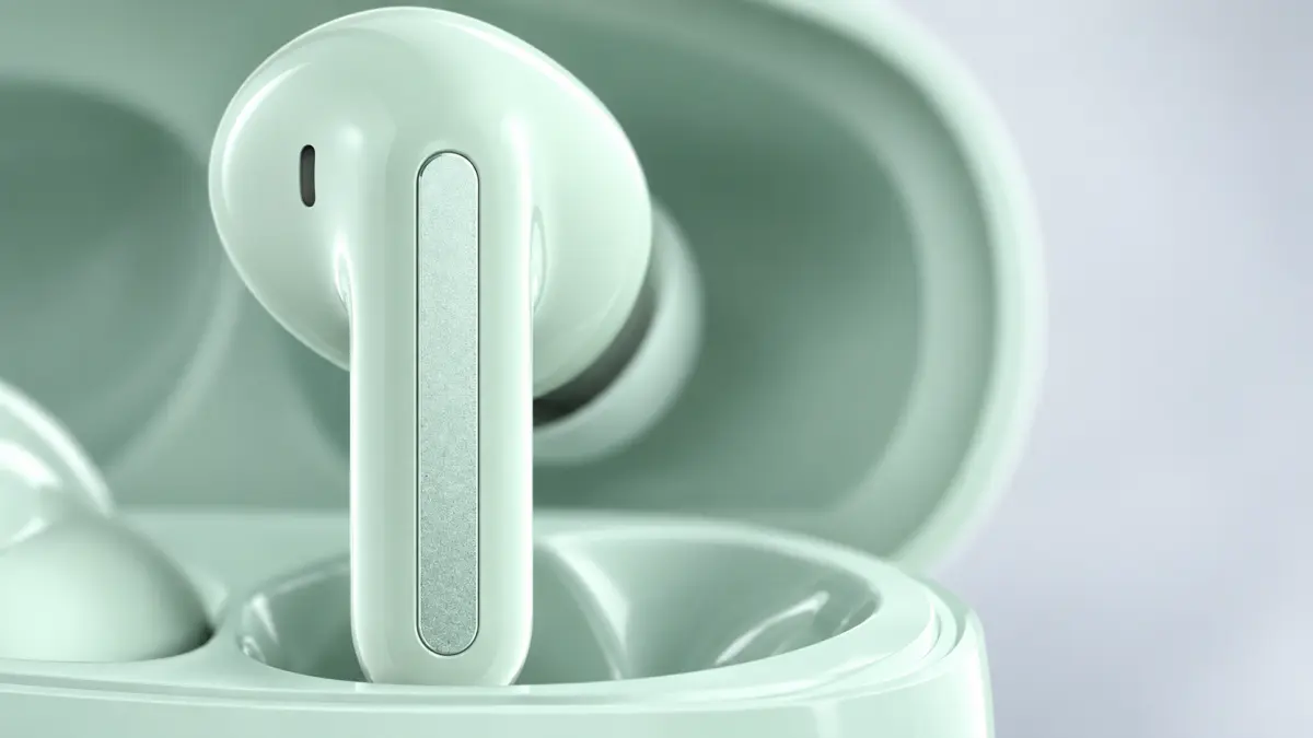 Close-up of a mint wireless earbud in an open charging case.